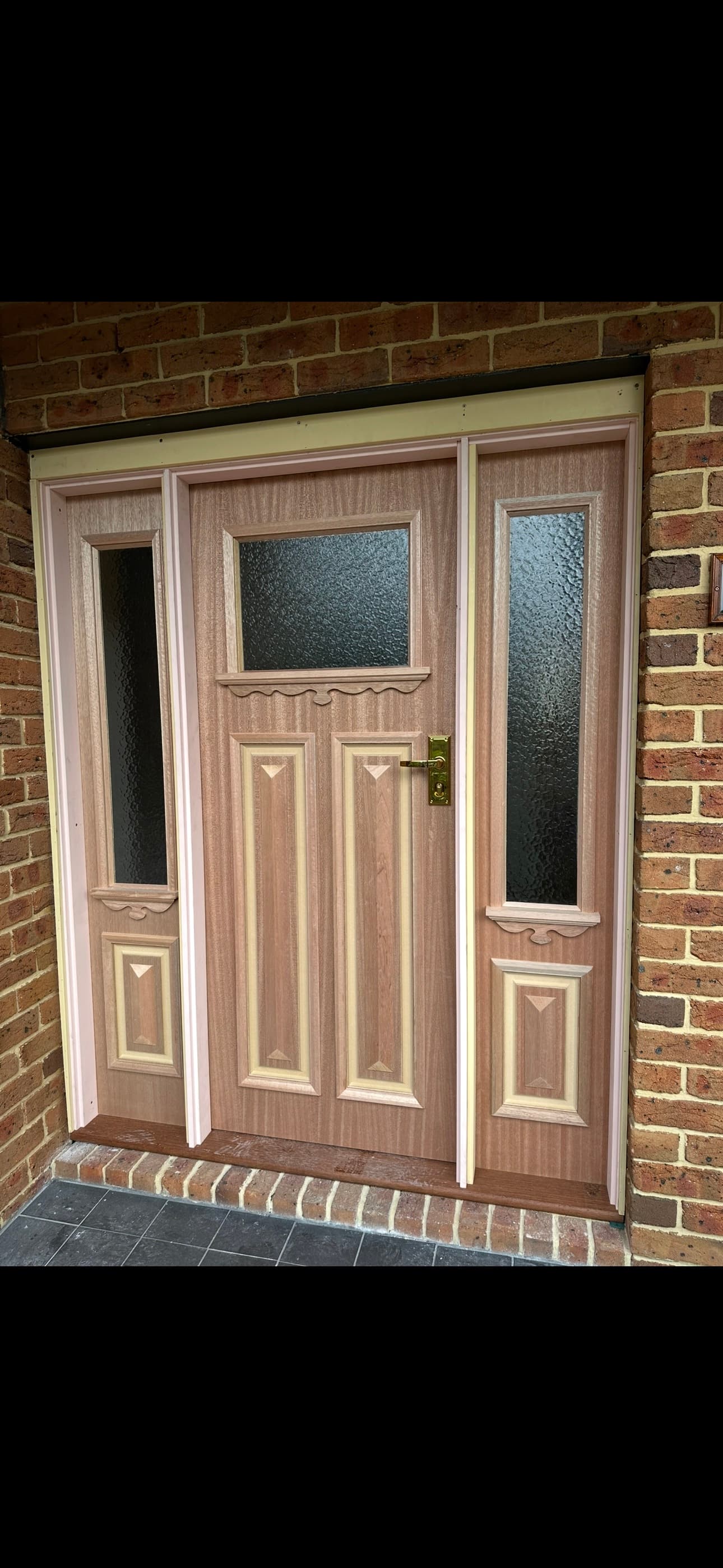 Solid timber front door with twin sidelight panels — raised panel detail, brass hardware