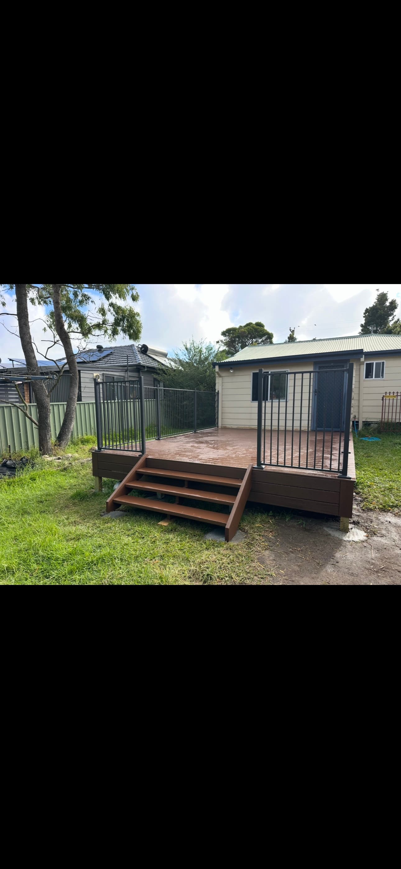 Black tubular steel safety fence — composite deck surround with access gate